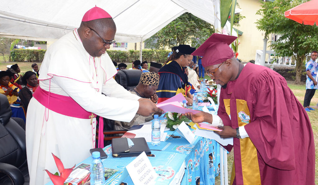 Bishop handing attestation to Graduate